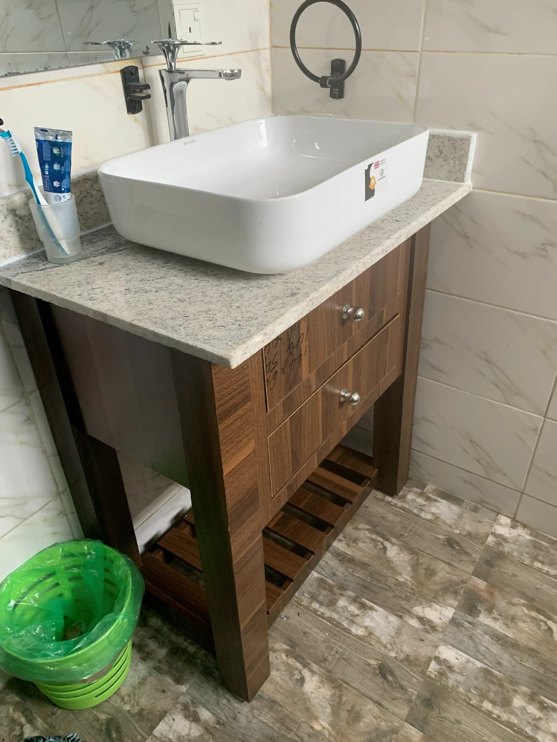 Walnut vanity carcass installed under a stone top before the second fix.