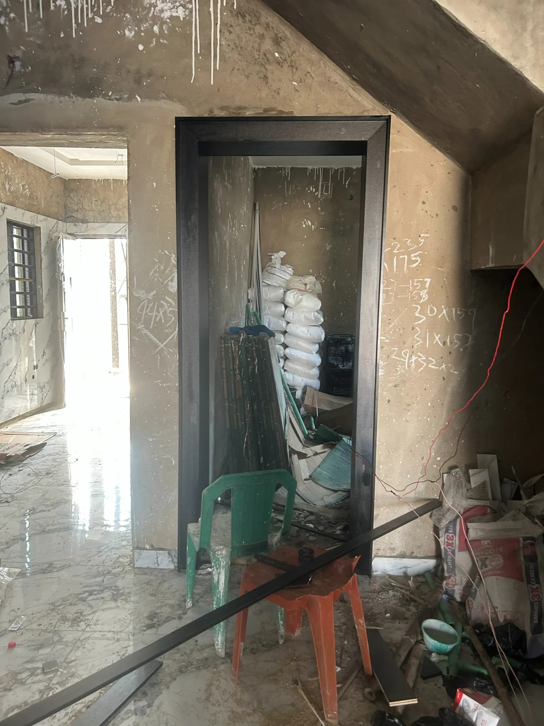Black door frame fitted in an unfinished room, with no door leaf yet hung.