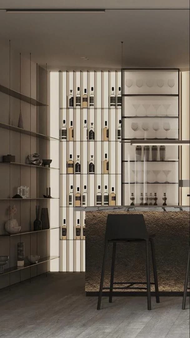A bar with backlit bottle shelving, glazed glassware cabinet and a stone-fronted counter.
