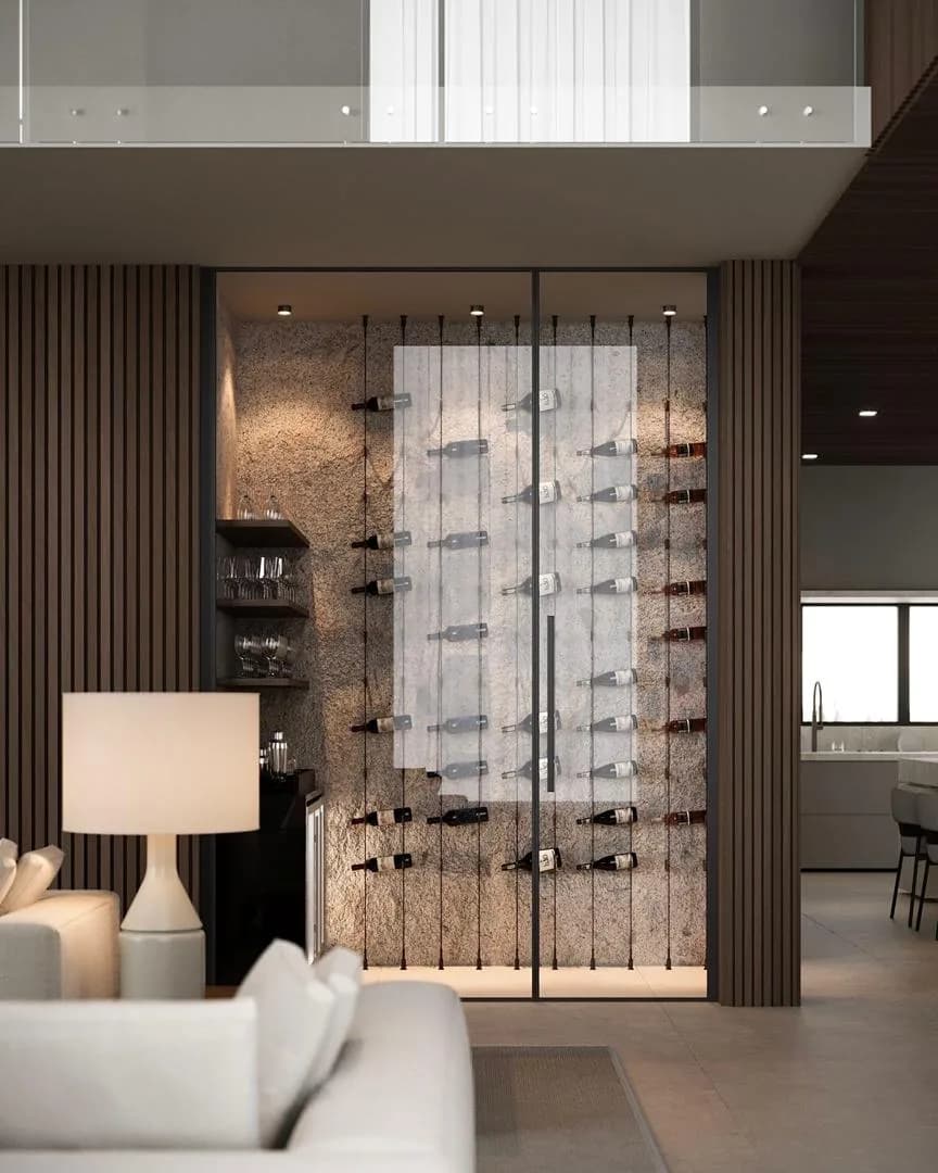 A glass-walled wine cellar with cable racking set into a fluted timber wall beside a lounge.